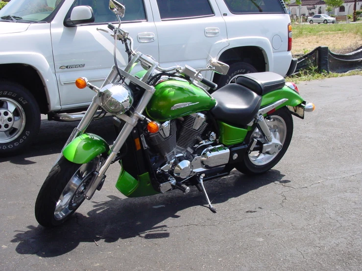 a lime green motorcycle parked next to a white truck