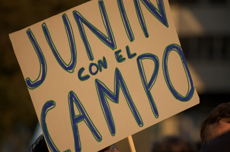 a white sign that says junior campo with blue writing