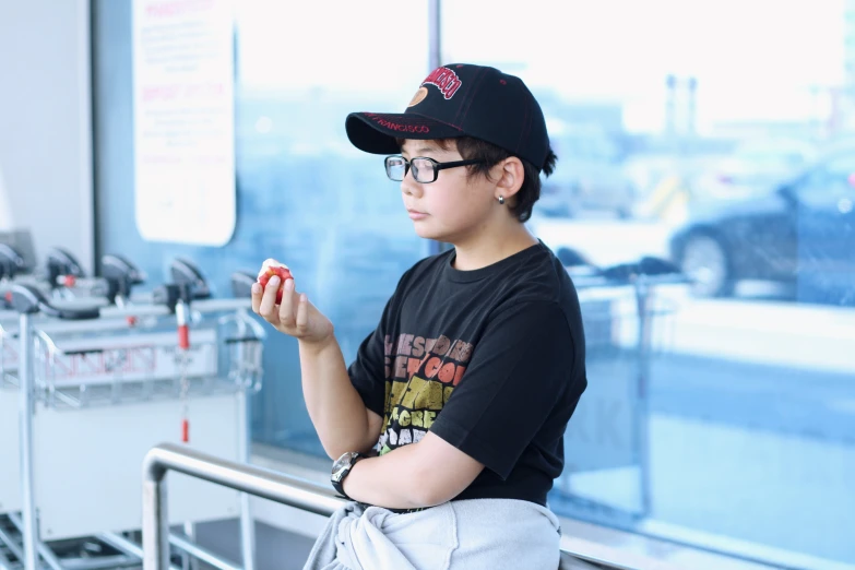 a boy in glasses holds soing at his hands