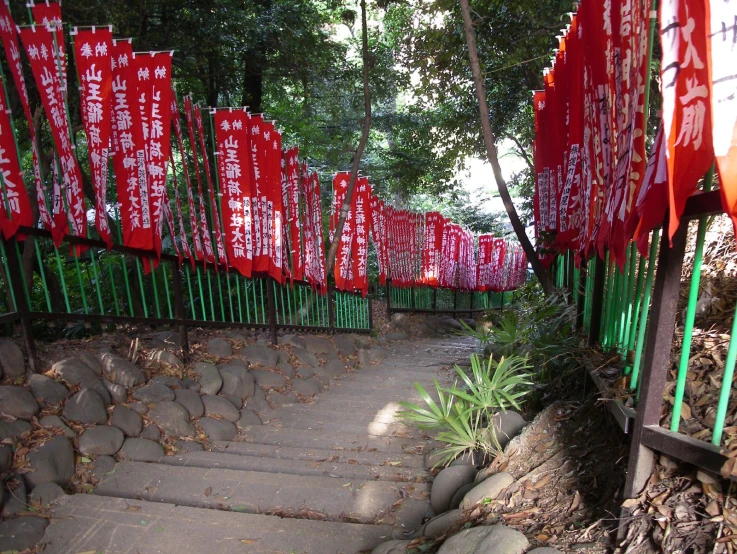 red flags with asian writing are attached to a fence