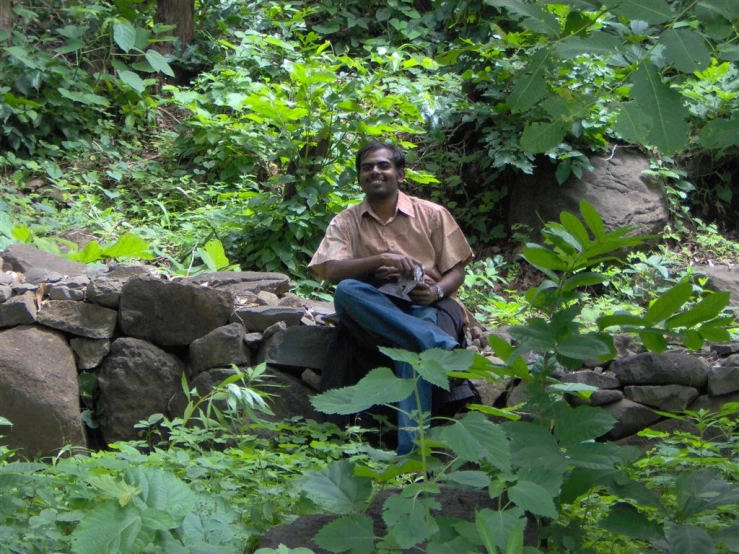 the man is posing for a picture in the woods