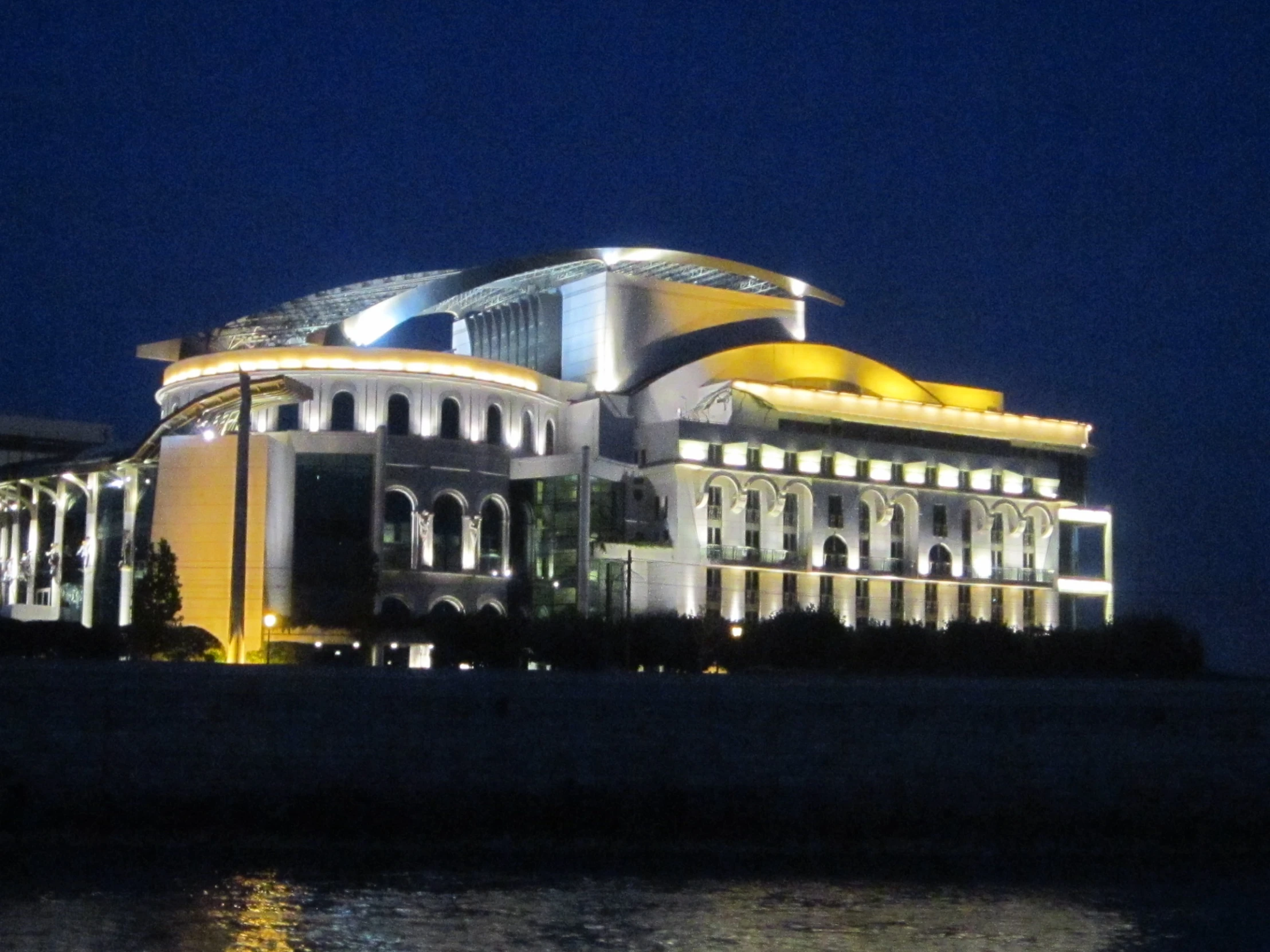 an exterior view of a large building lit up at night