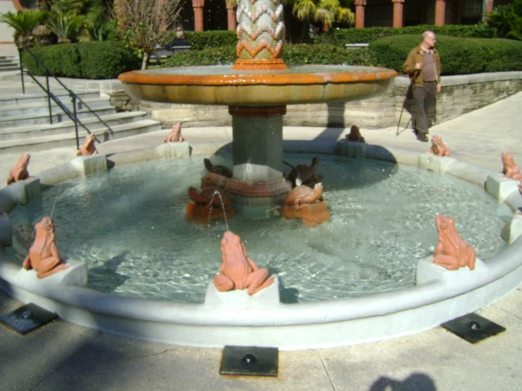 a fountain with people inside and a woman at the foot of the fountain
