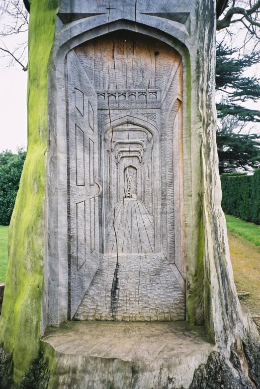 a monument sits in a park near a big tree