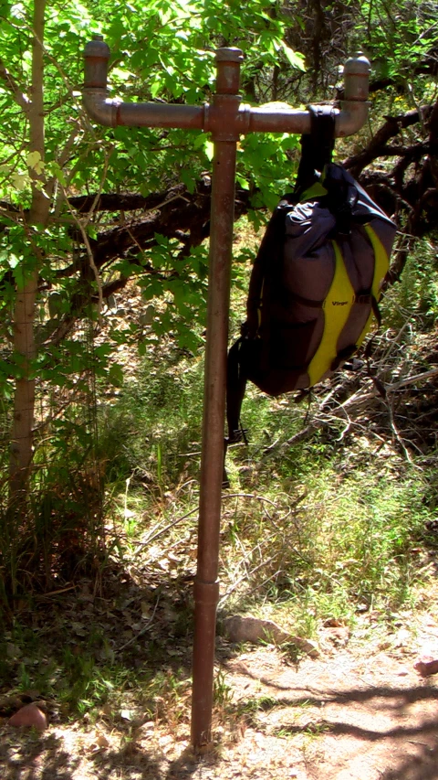 a duffel bag sitting in the shade near a tree