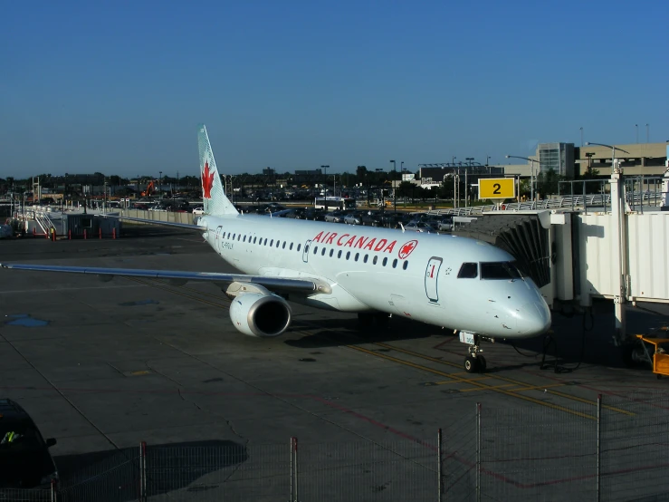 an airplane parked at an airport terminal with people looking on