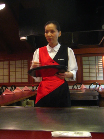 a woman wearing an apron, holding a plate