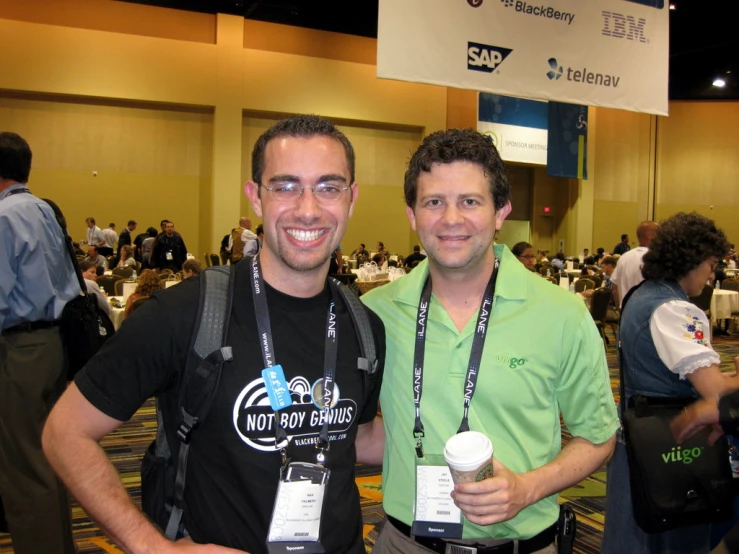 two men smile as they stand near each other