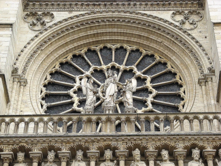 a fancy stone building has statues on the top and sides