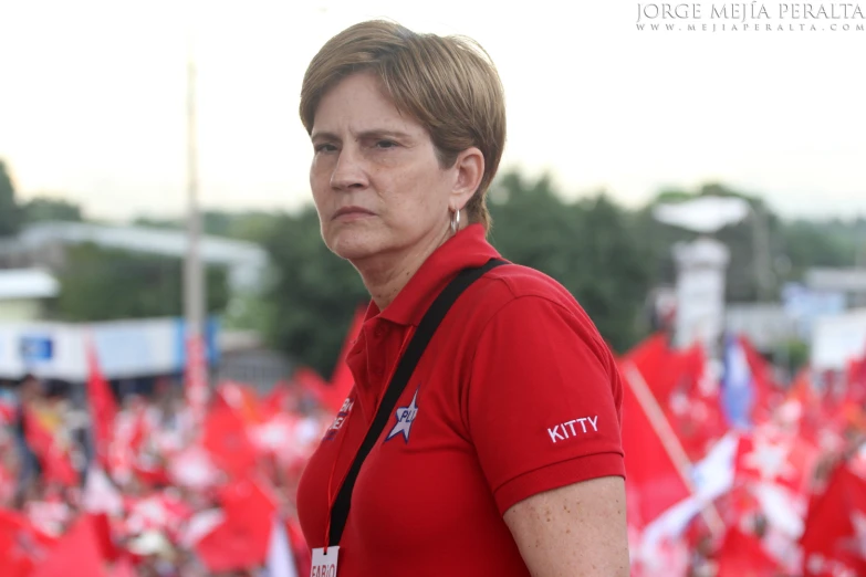 woman wearing a red polo shirt and carrying a cellphone