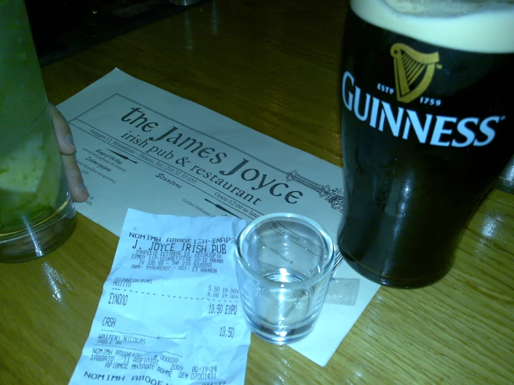 the receipt has been placed next to a pint of beer and a receipt