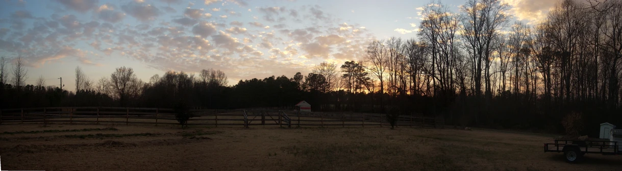 a fenced in field with a horse in the background