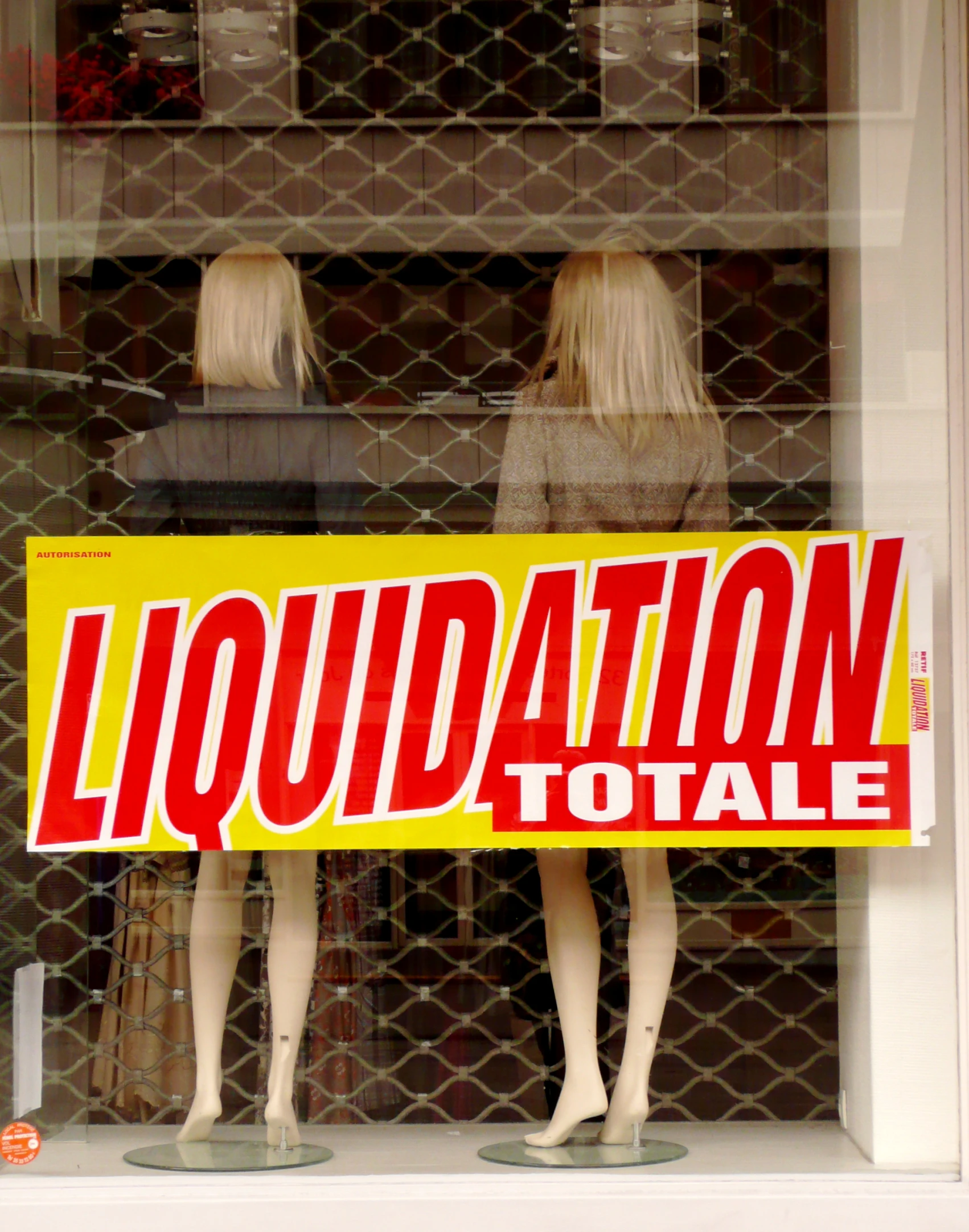 a sign is displayed behind a display of mannequins