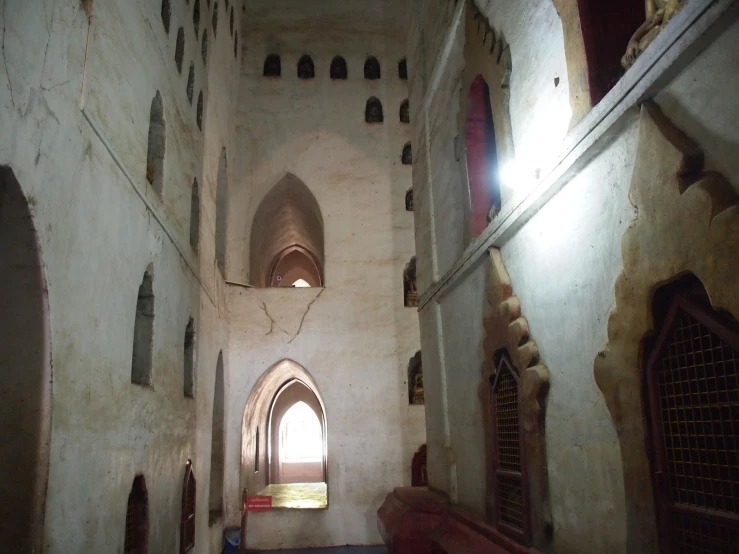 this long narrow hallway has white walls and arched doorways