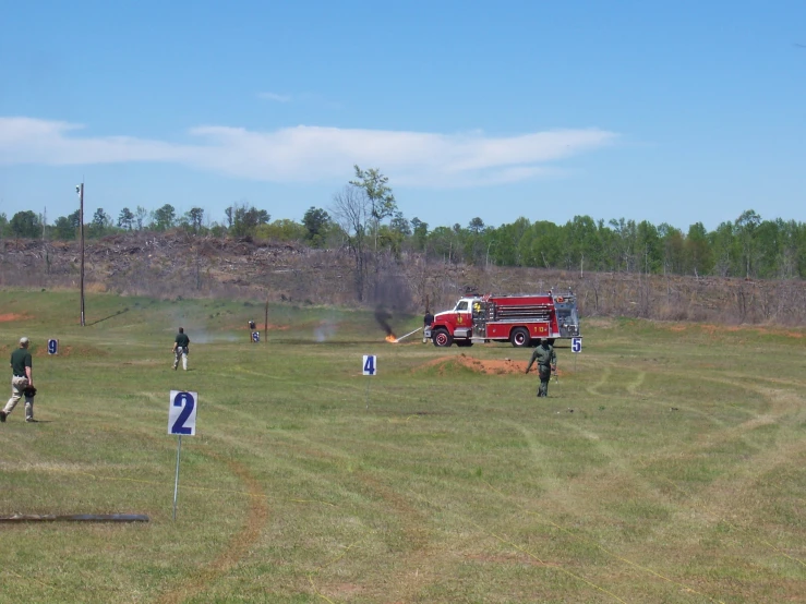 a group of people watch a fire truck on a field
