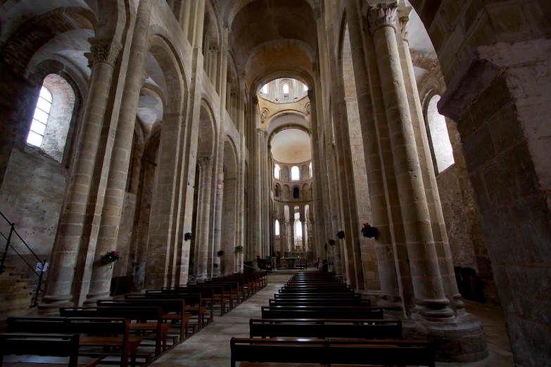 inside of an empty cathedral that has chairs on each side