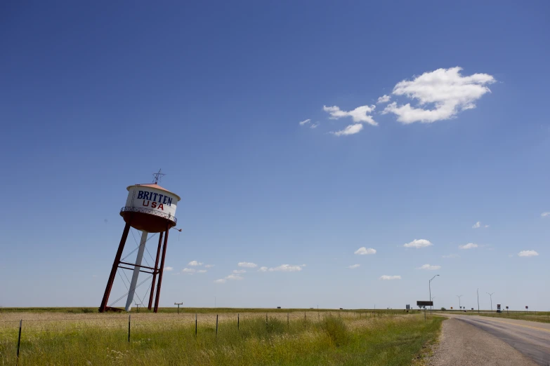 a large water tower sitting in the middle of a rural field