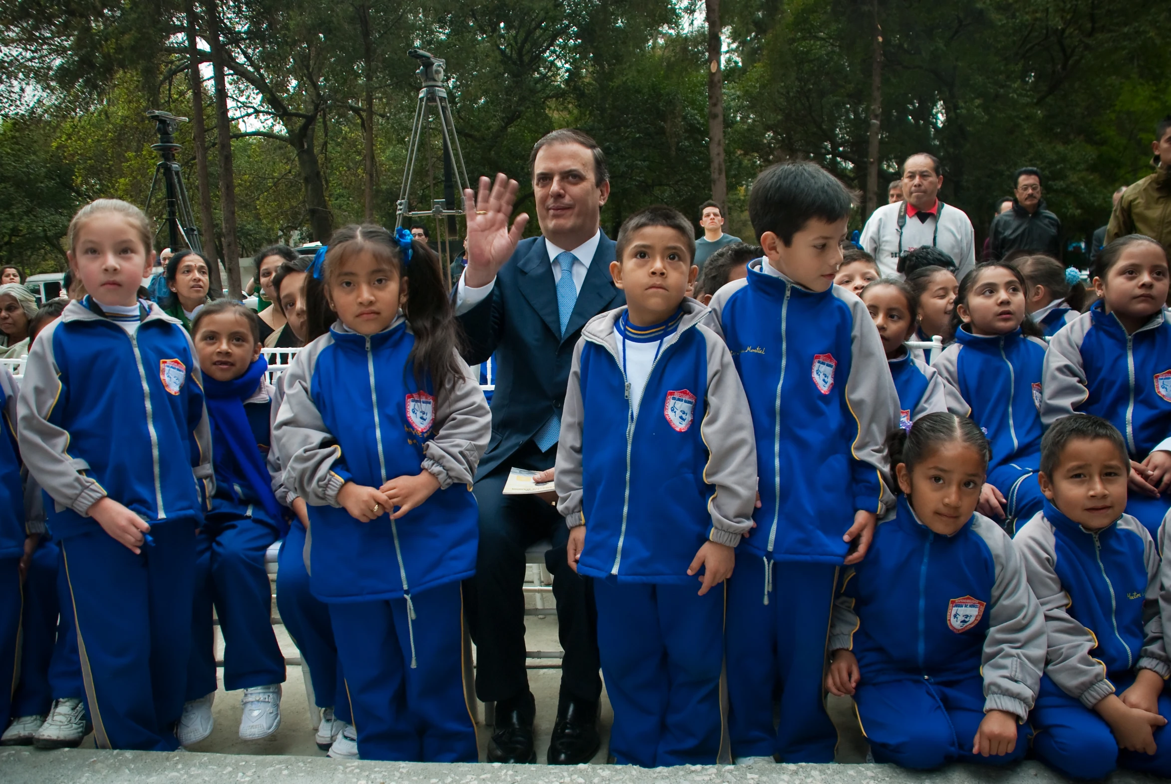 a group of children standing in front of a man and woman