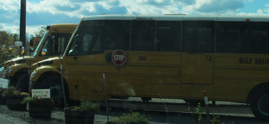 a yellow school bus next to another parked yellow bus