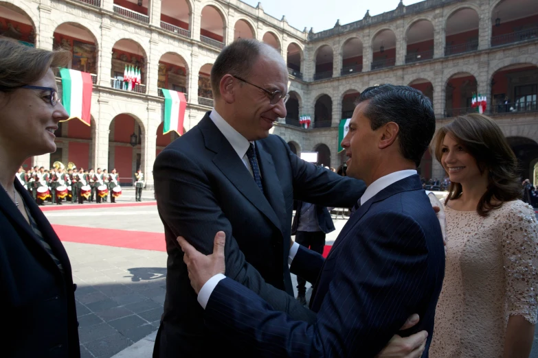 man in suit pointing at another man wearing suit and tie