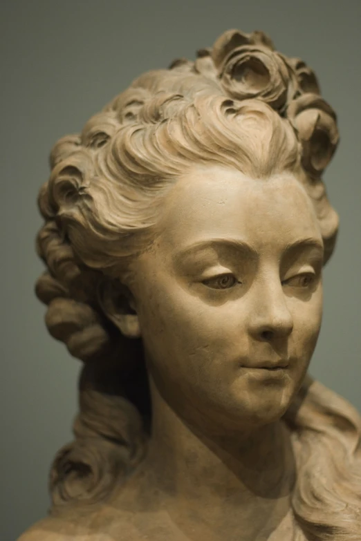 close up of a marble statue wearing flowers in her hair