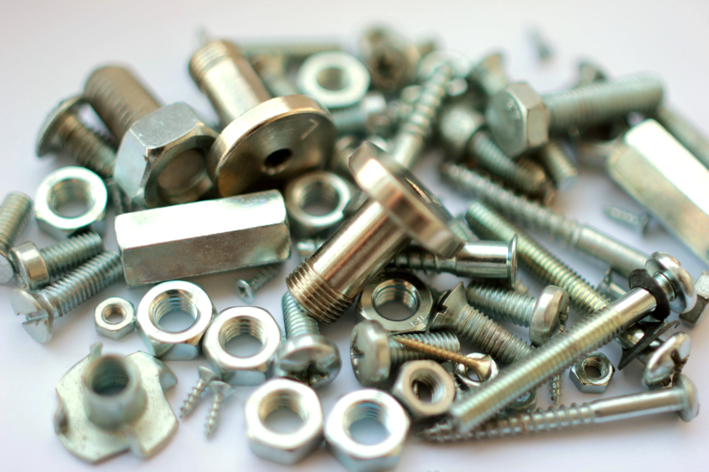 multiple nuts and bolts are piled on each other
