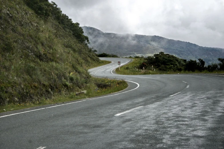 an empty road near the edge of a hill