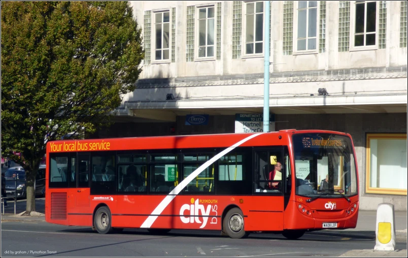 a red bus stopped on the side of the street