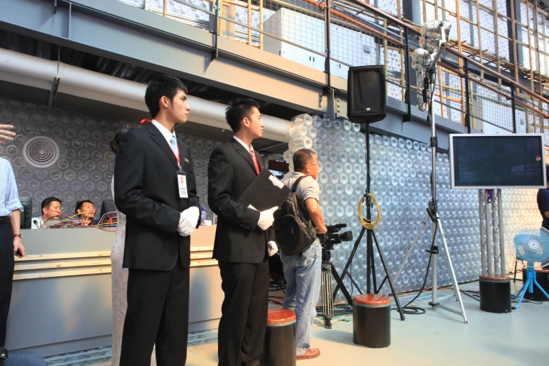 men in suits are looking at an information center