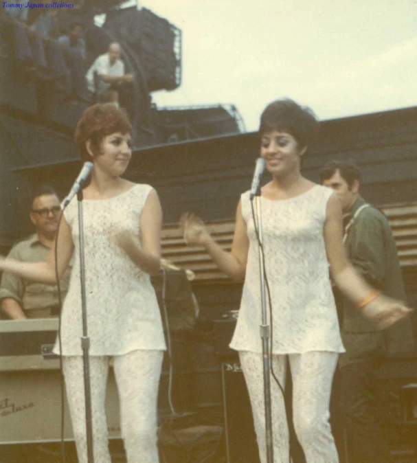 two women standing near each other, with microphones in hand