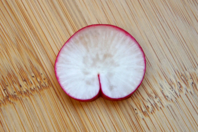 a close up image of an apple cut in half on a wood table