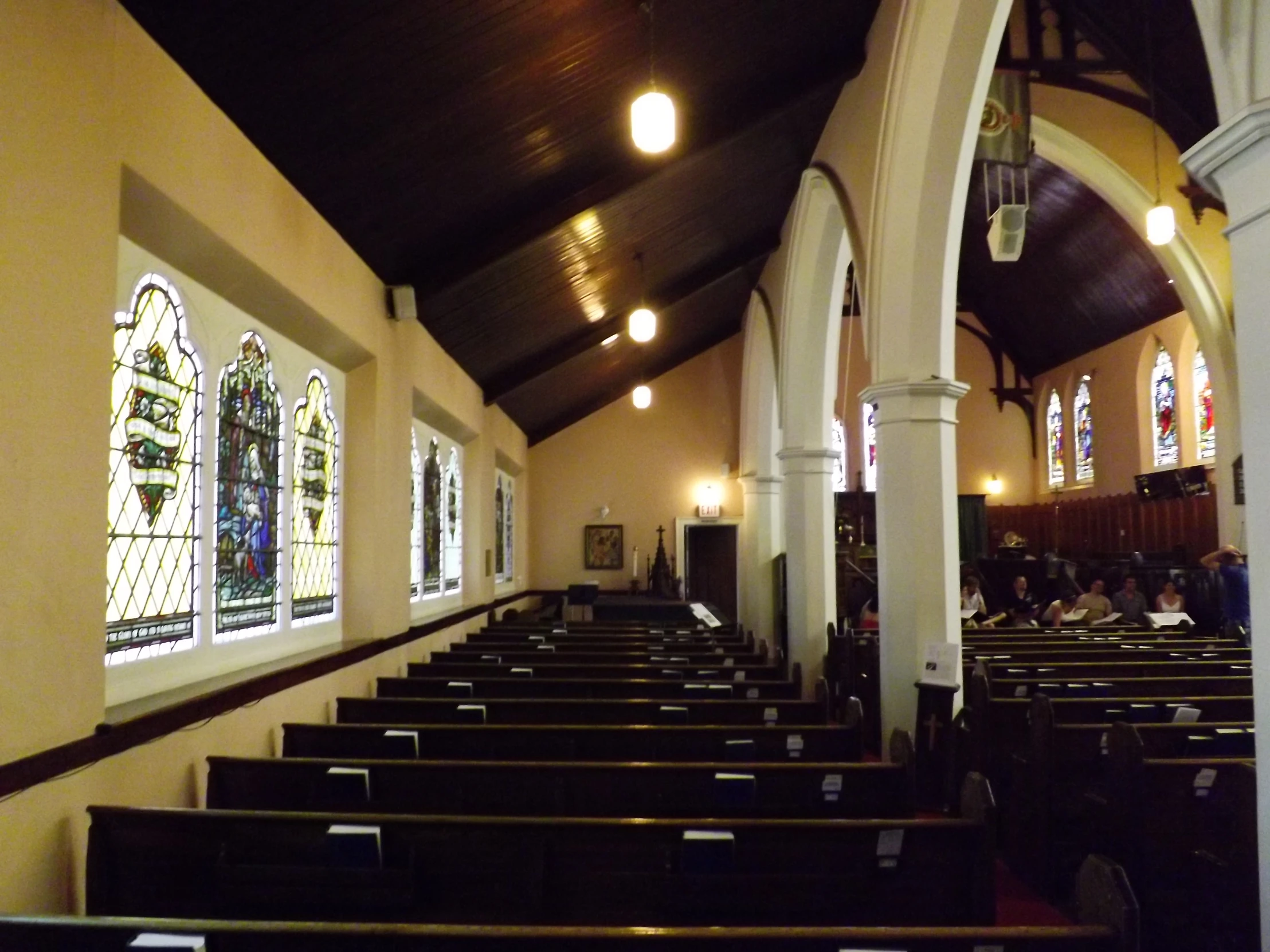 a church has three stained glass windows and pews