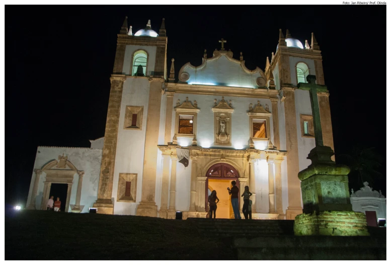 people standing in front of a large white church