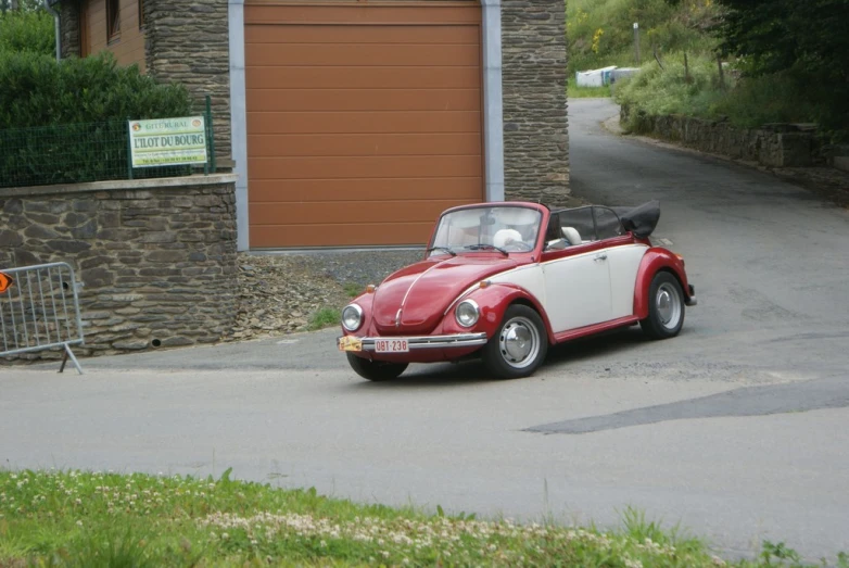 a red and white car parked by the garage