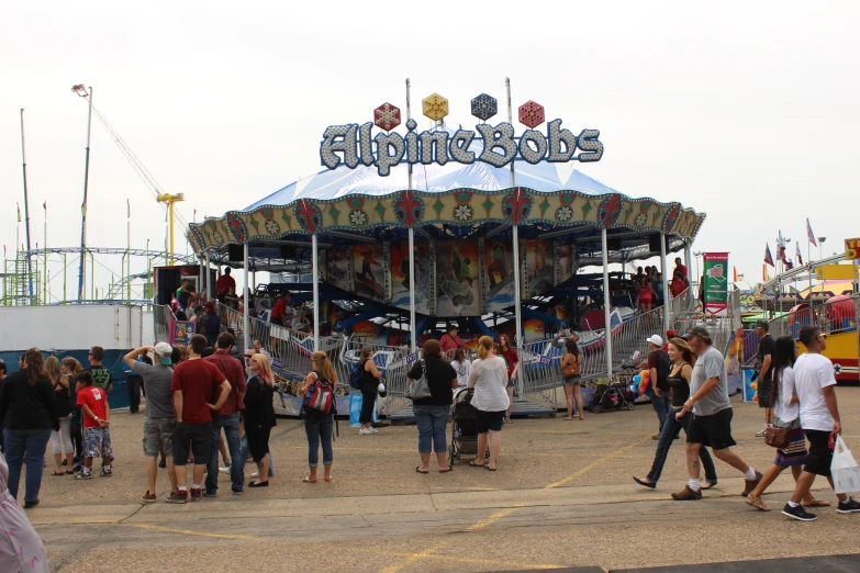 an amut ride in the middle of the day with many people walking around it