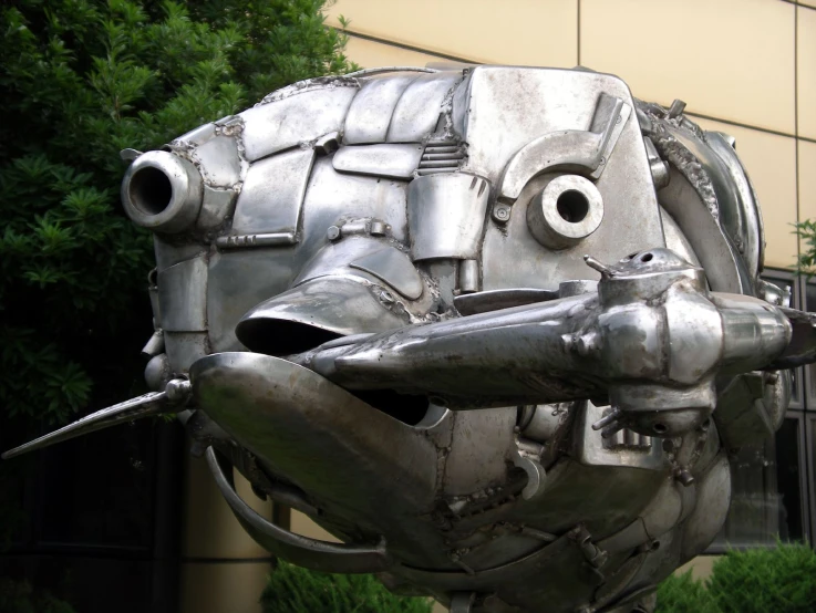 a large metal face on display on top of grass