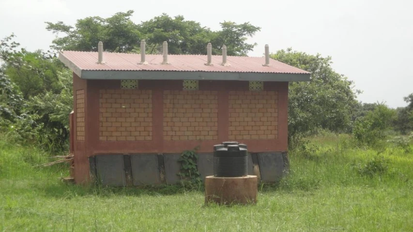 a small building with a brick facade and water source