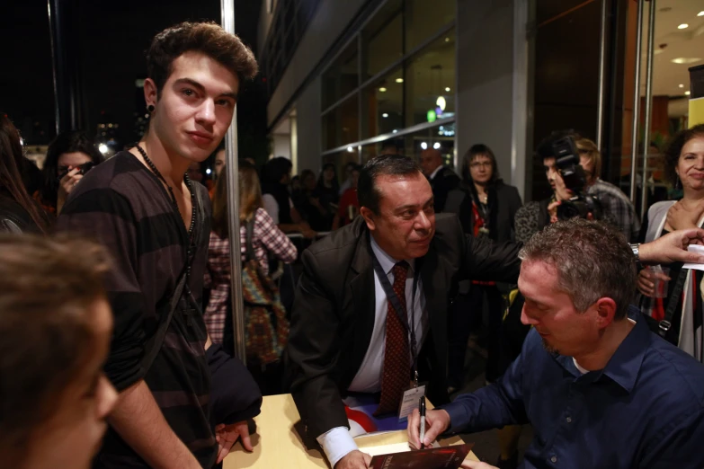 a man signing a note in a box at a table