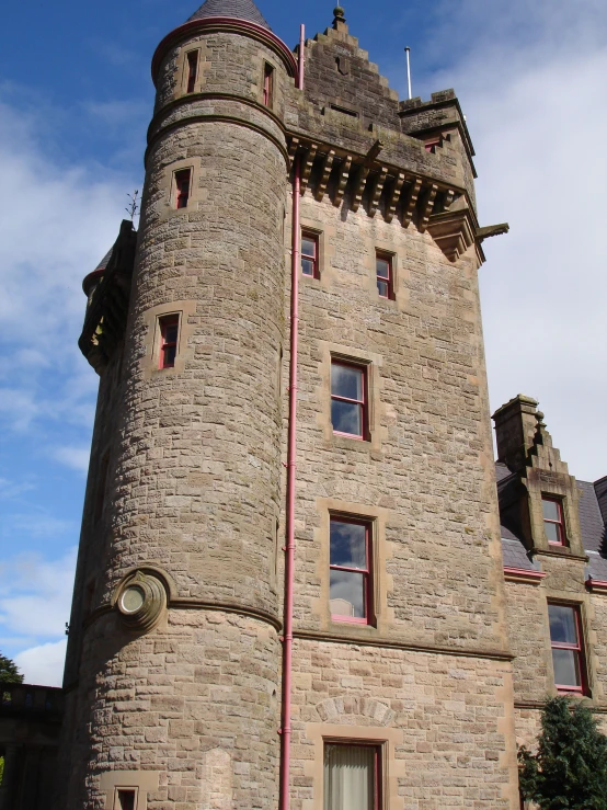 a tall castle with red trim sits high up
