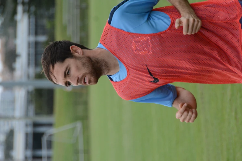 a male in a red and blue shirt with a soccer ball in his hand