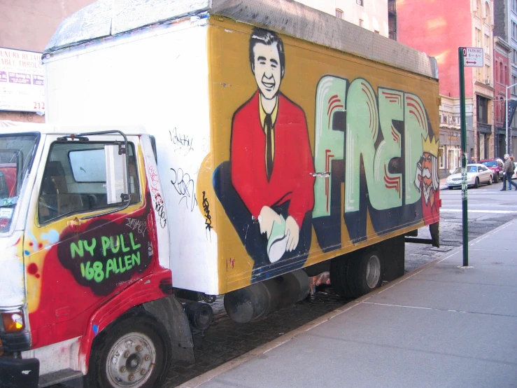 a yellow truck with a man painted on it