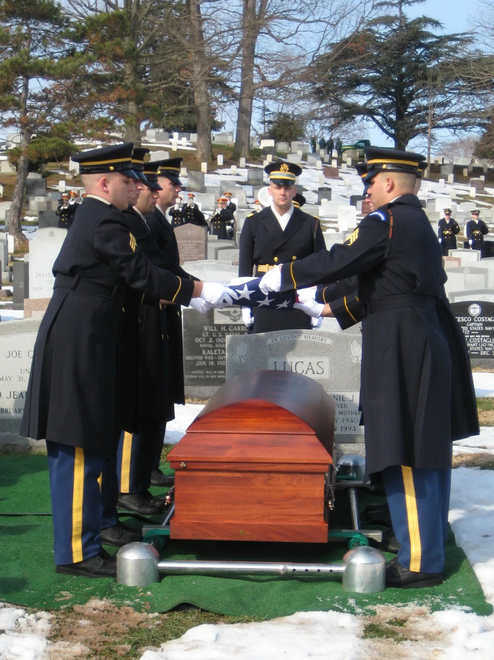 a man in a dress blue uniform shaking another mans hand over to a man in military uniform