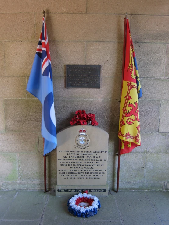 two flags sitting next to a stone memorial