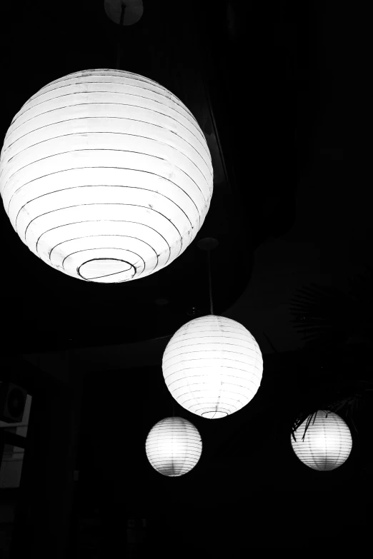 three round lights sitting below a ceiling in the dark