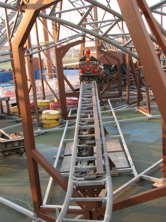 some people are standing near a roller coaster