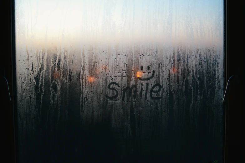 the words smile painted on a frosted glass window