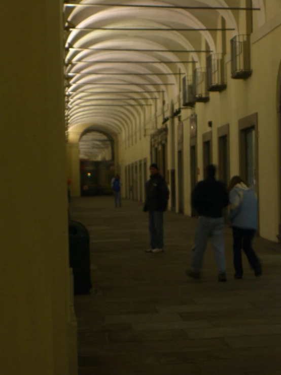 people are walking down a long walkway way