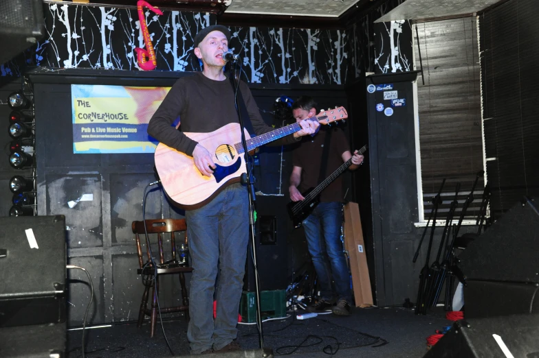 a man is playing the guitar in front of other musicians