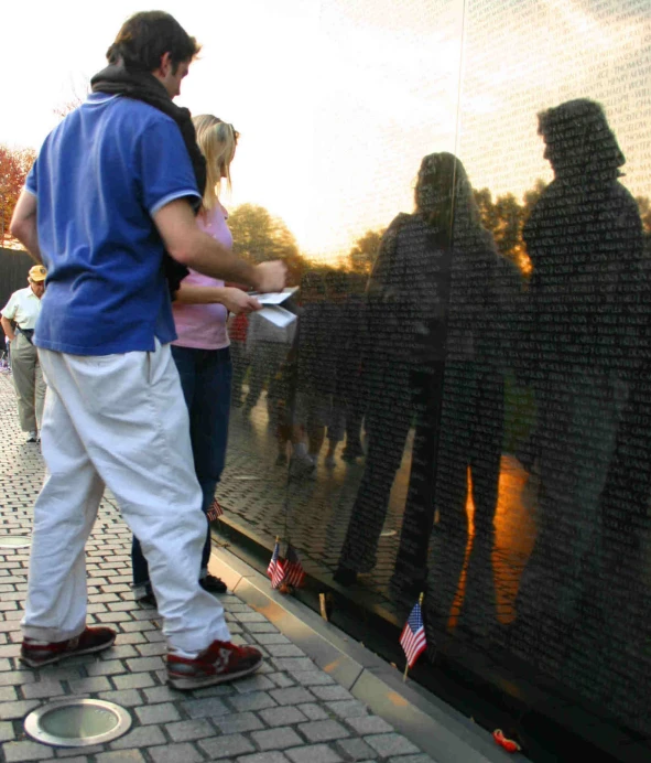 a man is standing in front of a black wall