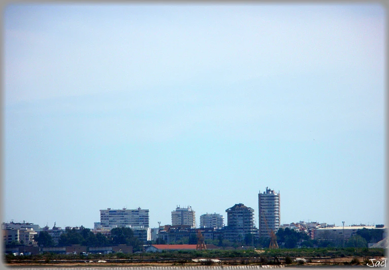 large plane flying over a city with tall buildings